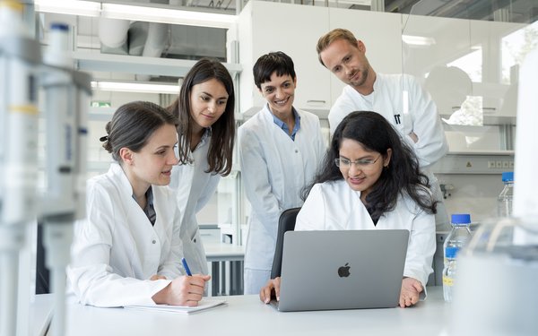 Arbeitsgruppe von Frau Prof. Kerstin Stemmer im Labor gemeinsam am Laptop