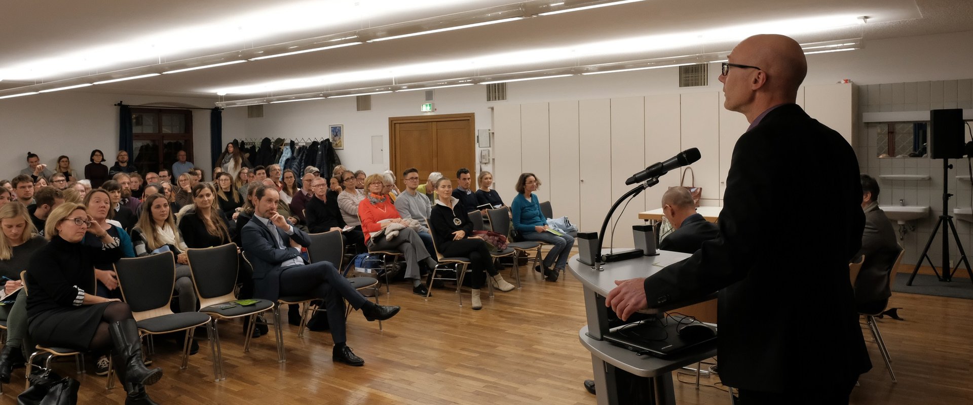 Das Bild zeigt Prof. Nuscheler vor dem Publikum beim 5. Augsburger Gesundheitsdialog