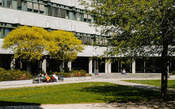 Studierende sitzen im Innenhof