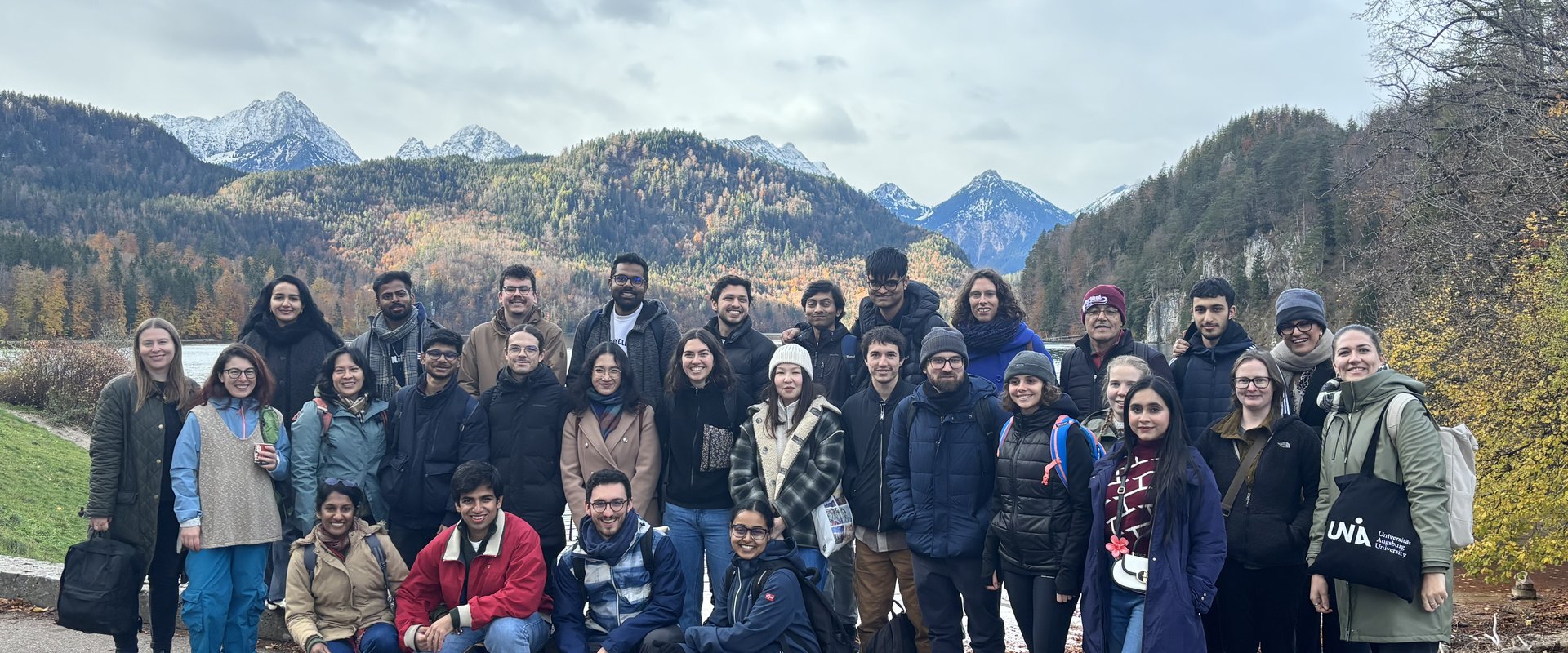 Gruppenbild von international Forschenden vor dem See und mit Bergpanorama bei Schloss Neuschwanstein