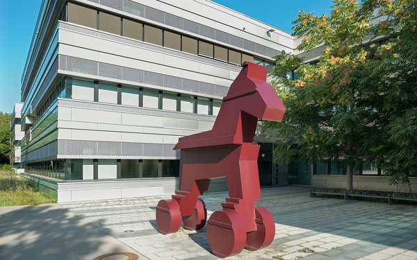 Auf dem Bild sieht man ein überdimensionales großes rotes Pferd, welches an das historische trojanische Pferd erinnert.