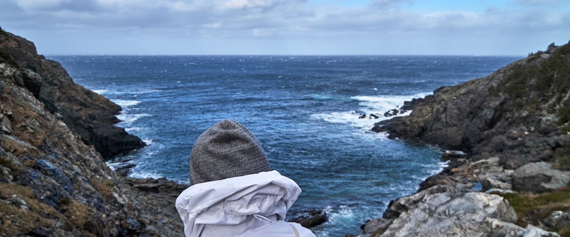 Person sitzt am Fjord