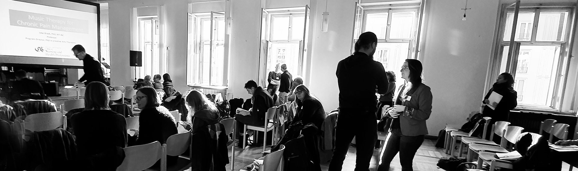großer Saal mit Musiktherapiestudierenden in der Pause
