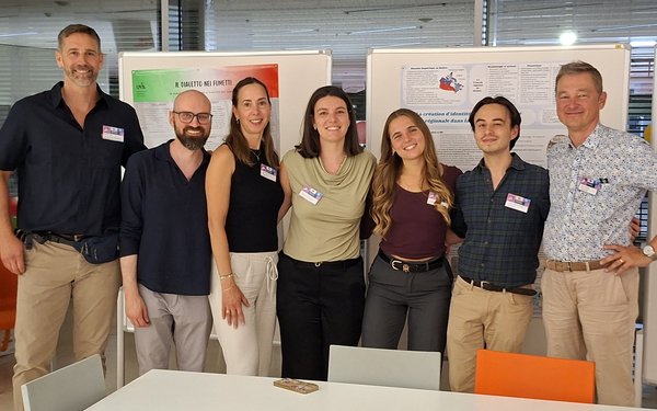 7 Mitarbeiter des Teams Romanische Sprachwissenschaft stehen vor den Plakaten des Romanistik-Stands der LNDW