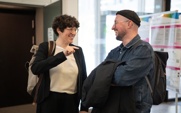 Ein Mann und eine Frau lachen sich bei einer Veranstaltung des Projekts ?KodiLL zu, w?hrend die Frau mit dem Finger in die Luft zeigt.