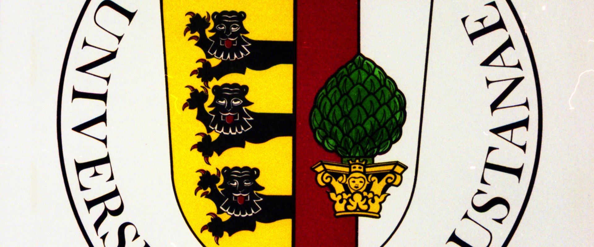 Das Wappen der Universität Augsburg besteht aus eine Darstellung einer grünen Zirbelnuss und drei schwarzen Löwen sowie den Schriftzügen "Universitatis", "Sigillum" und "Augustanae".