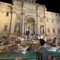 Mann vor dem monumentalen Trevibrunnen in Rom