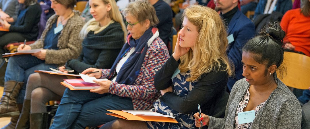 Studentinnen und STudenten der Musiktherapie während eines Vortrags. In der ersten Reihe sitzen Studentinnen unterschiedlichen Alters und vielfältigem Erscheinungsbild.
