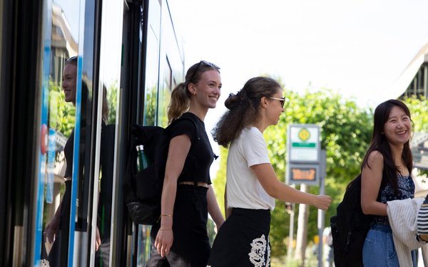 Studierende steigen aus der Straßenbahn aus