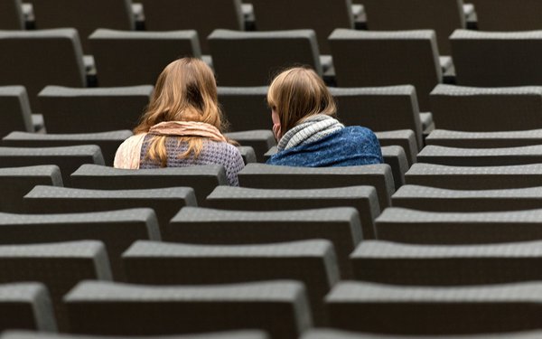 Zwei Studentinnen sitzen alleine im Auditorium