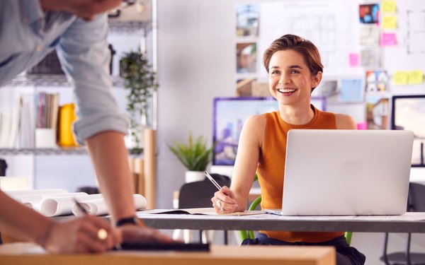 Studentin arbeitet am Laptop und lächelt