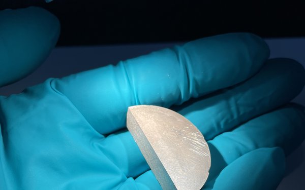 Beispielhaft die Kühlmaterialien in gepresster Form und mechanisch einfach bearbeitbar, auf einem blauen Handschuh präsentiert
