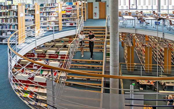 Studentinnen auf der Treppe in der Bibliothek