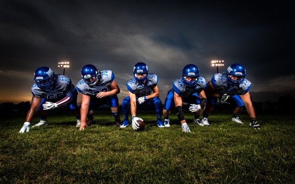Fünf American Football-Spieler in der Grundstellung