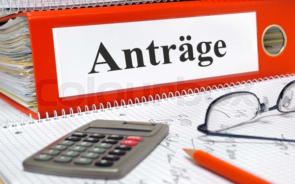 Ordner "Anträge", Bleistift und Rechenmaschine