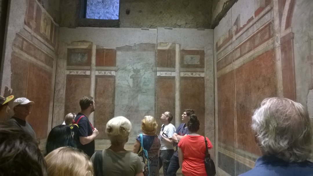 Römische Wandmalereien, davor ExkursionsteilnehmerInnen und MuseumsbesucherInnen