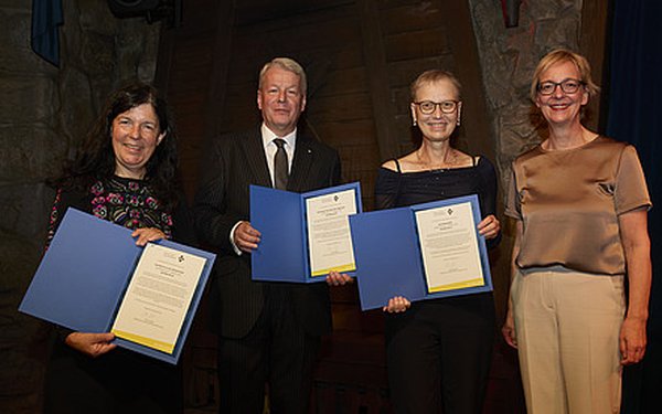 Elisabeth André, Peter Liggesmeyer und Andrea Martin halten ihre Urkunden und lächeln in die Kamera. Daneben steht GI-Präsidentin Christine Regitz.