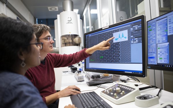 Zwei Beschäftigte der Universität Augsburg am PC-Arbeitsplatz