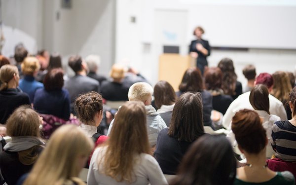 Voller Hörsaal mit Sprecherin