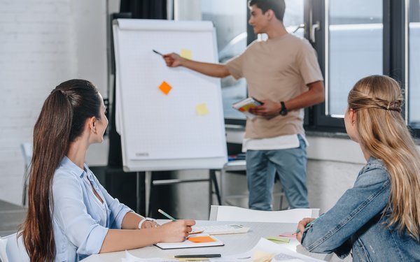 Junge Menschen bei einer Präsentation am Flipchart