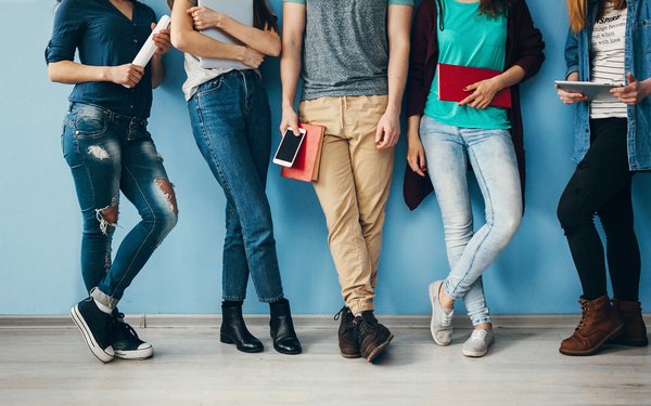 Studierende mit Büchern, Smartphone, Tablet