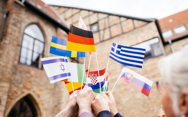 Menschen halten Flaggen verschiedener europäischer Länder hoch