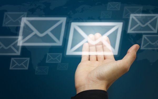 Hand trägt ein virtuelles Brief-Symbol auf blauem Hintergrund