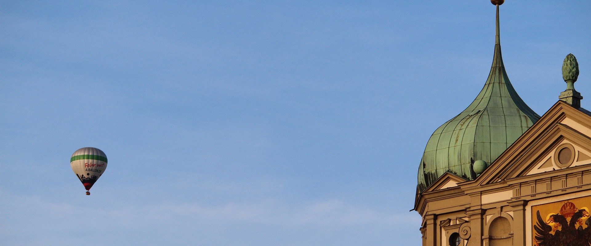 Bild vom Augsburger Rathaus, daneben ein Heißluftballon am Himmel