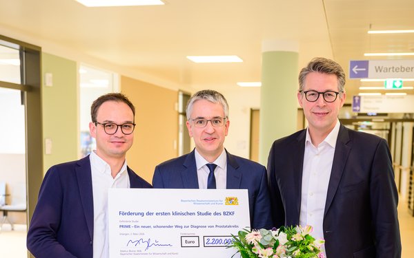 Prof. Dr. Matthias Keck, Prof. Dr. Matthias Eiber und Wissenschaftsminister Markus Blume bei der Scheck��bergabe.
