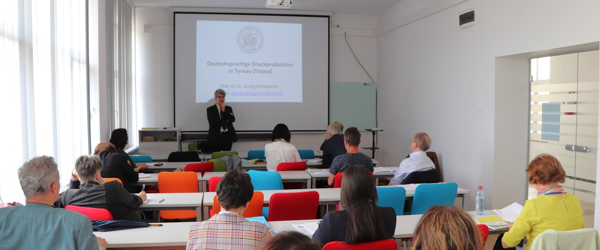Es sind Zuhörende während einer Präsentation der Konferenz zu sehen.