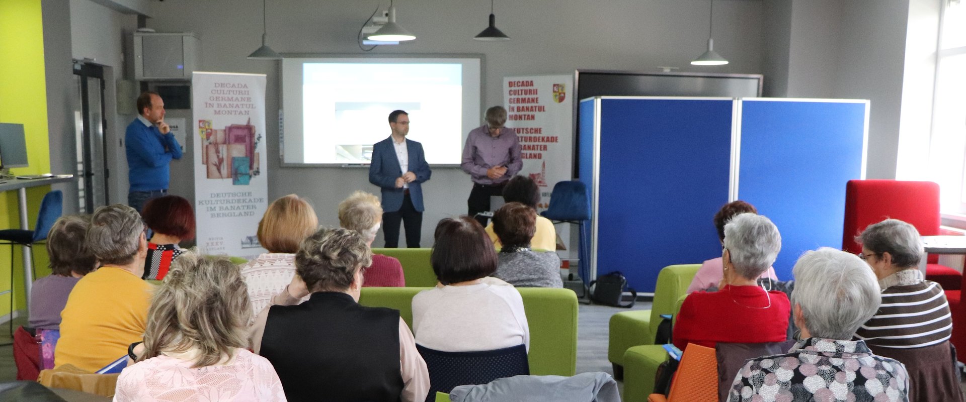 Es sind Herr Franz und Herr Wildfeuer w?hrend der Pr?sentation sowie das Publikum von hinten zu sehen.