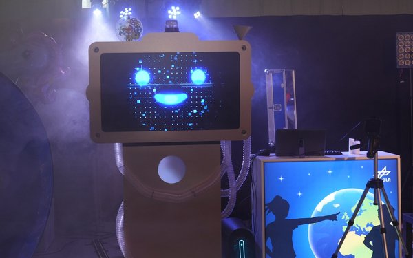 Roboter mit lachendem Bildschirmgesicht auf der Raumfahrtshow