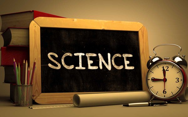 Bücher, Wekcer sowie Tafel mit Aufschrift "Science"