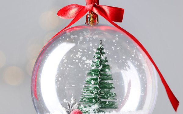 Eine weihnachtliche Glaskugel mit einer Winterlandschaft im inneren.