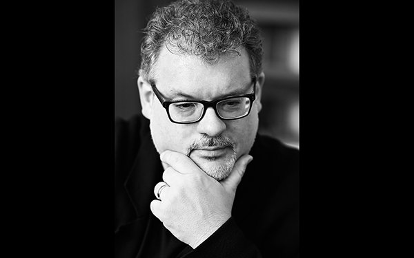 Schwarz-weiß-Foto von Prof. Dr. Dominik Wortig. Er schaut nach unten und hat die Hand am Kinn.