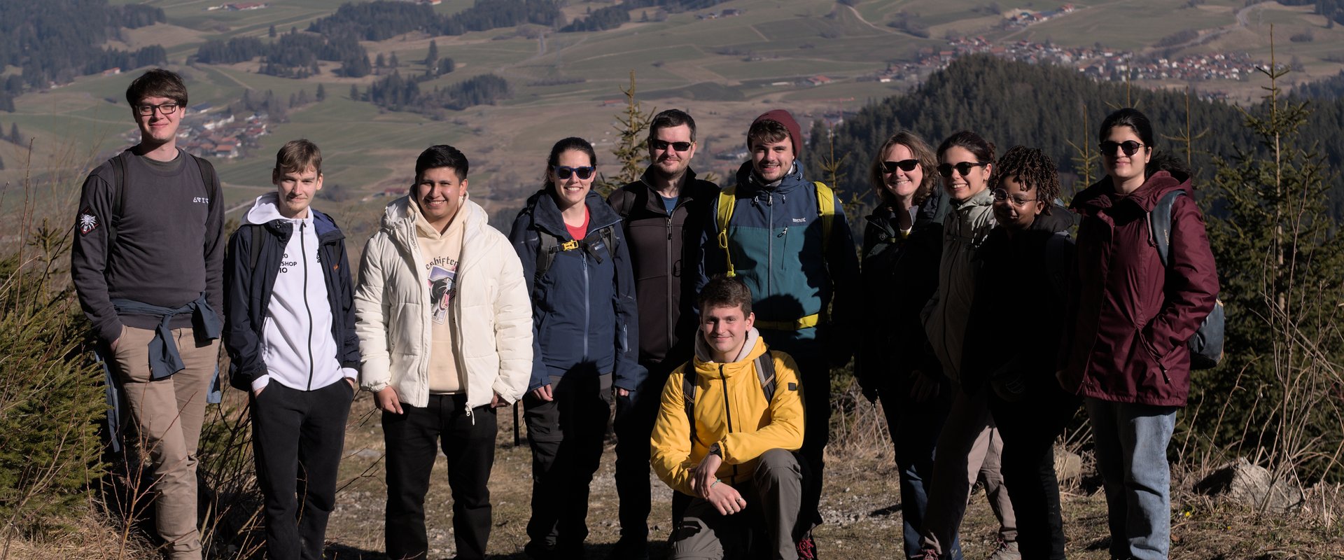This picture shows the group with the sectretary and two students on the mountain Alpspitze with the view into the valley