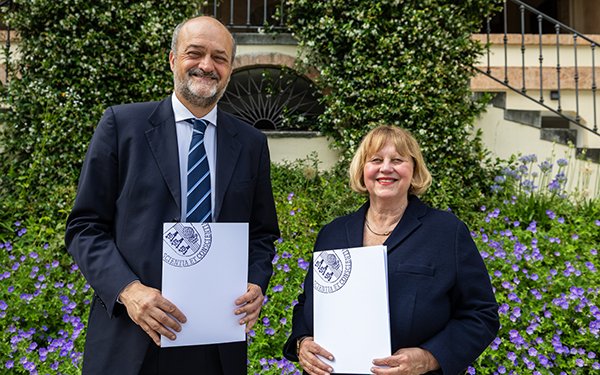 Die Präsidentin der Universität Augsburg gemeinsam mit dem Präsidenten der Universität Bergamo. Beide halten ein Dokument in den Händen.