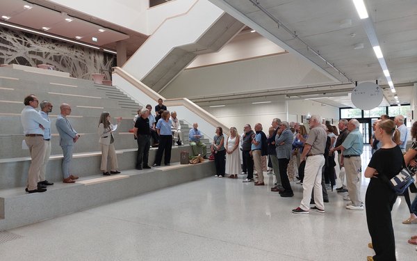 Gruppe von Menschen bei der Besichtigung im Atrium des neuen Lehrgebäudes Medizin