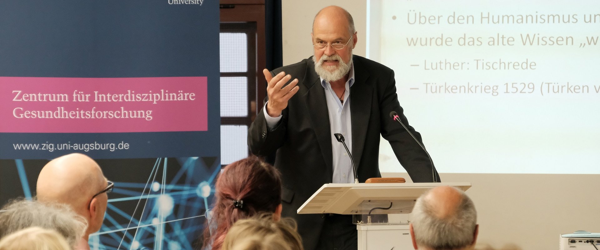 Das Bild zeigt den Redner beim 2. Augsburger Gesundheitsdialog