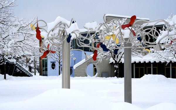 Brunnen im Winter mit Jura-Gebäude mit Schnee