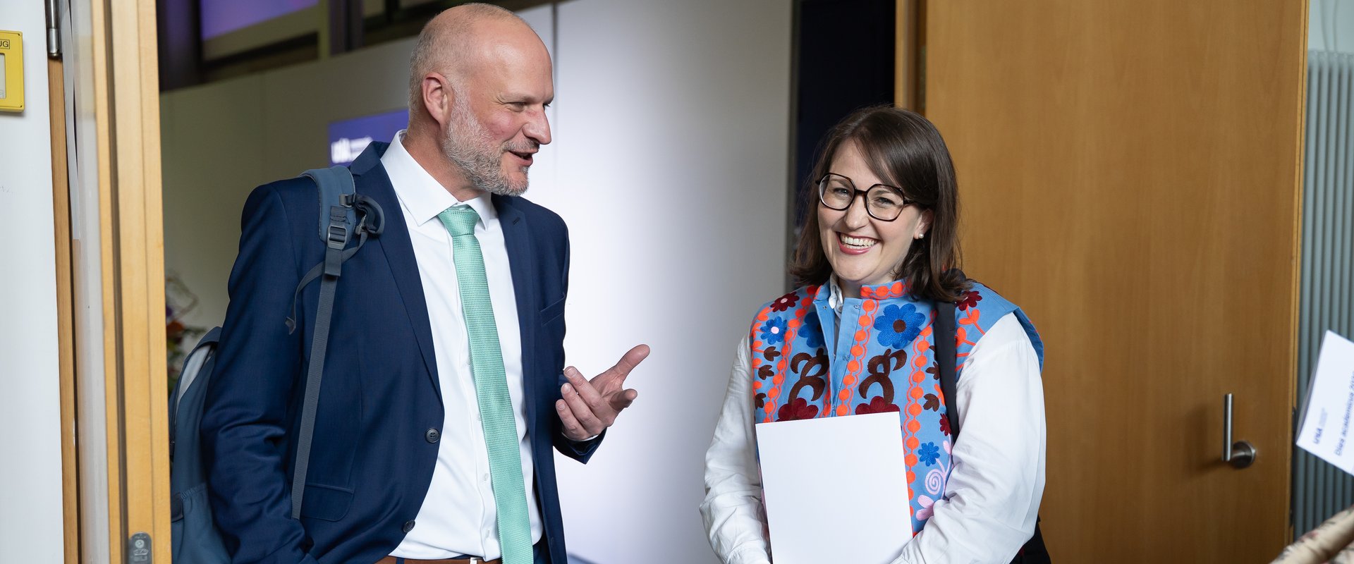 Katja Boser steht rechts, Christoph Lang links, Katja hält die Urkunde des Preises in der Hand