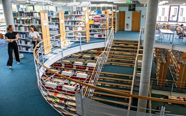 Studentinnen in der Bibliothek, Bücher, Regale