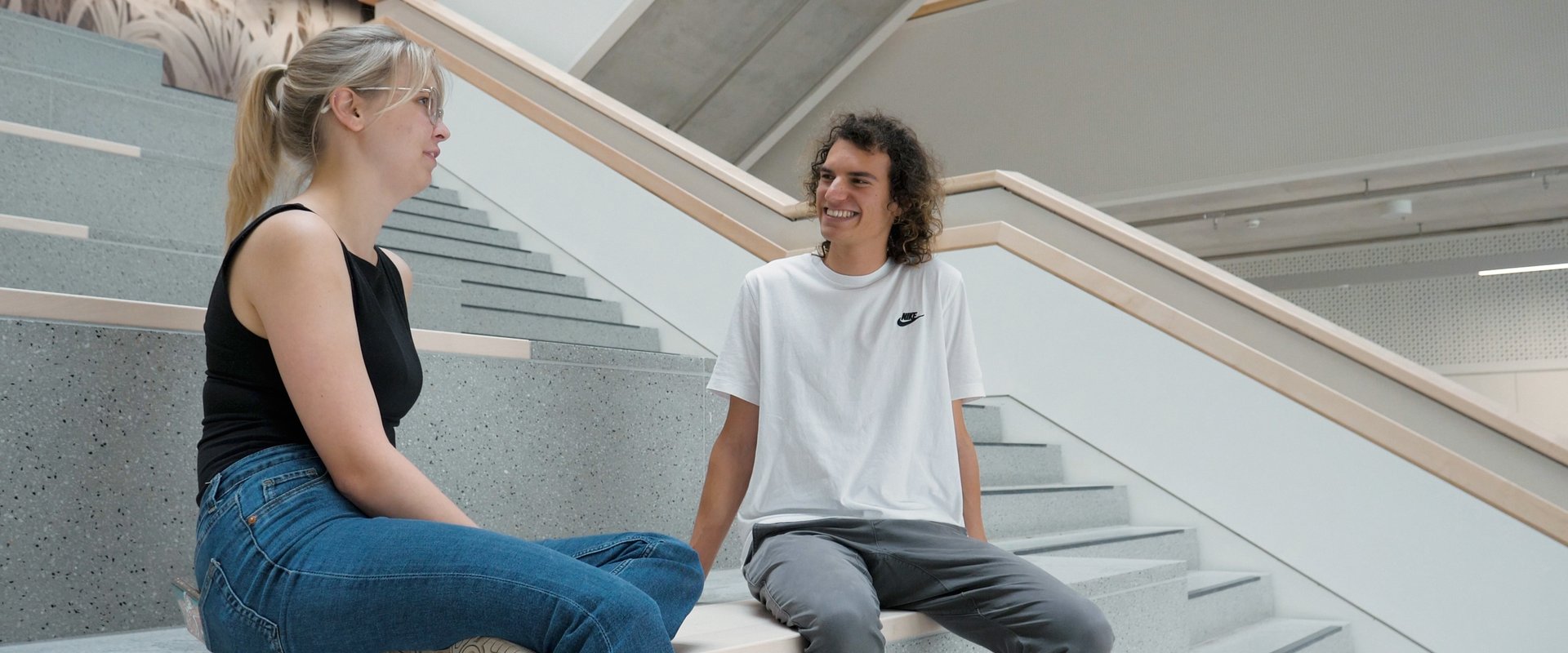Studierende auf Treppe im LGB Artikel Eröffnung Lehrgebäude
