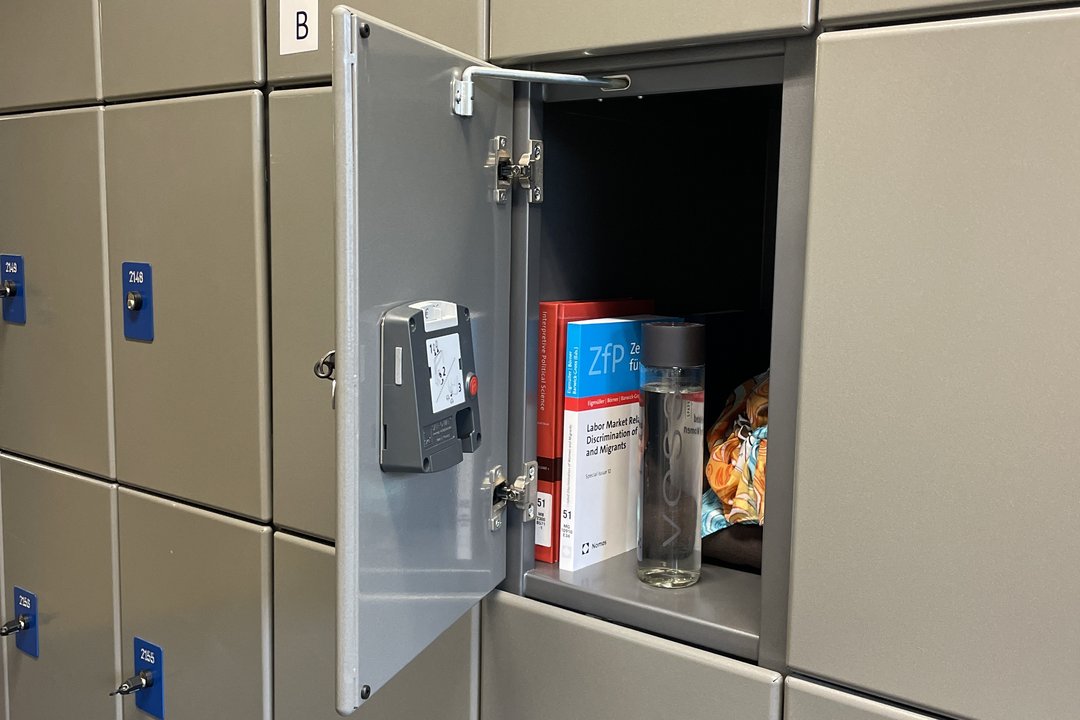 graues Schließfach mit geöffneter Tür, drinnen einige Arbeitsmaterialien