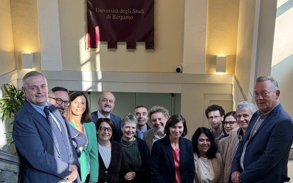 Delegation Bergamo steht auf der Treppe in der Uni