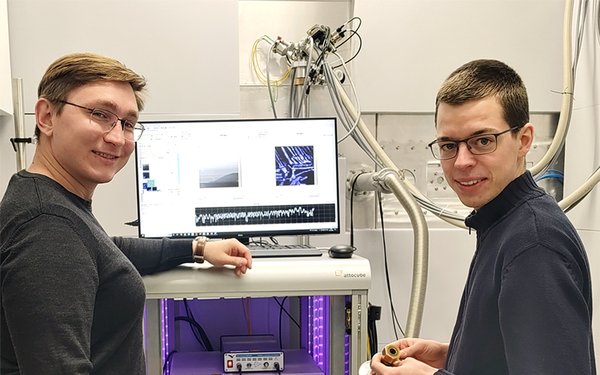 Zwei Forscher stehen vor einem Rasterkraftmikroskop