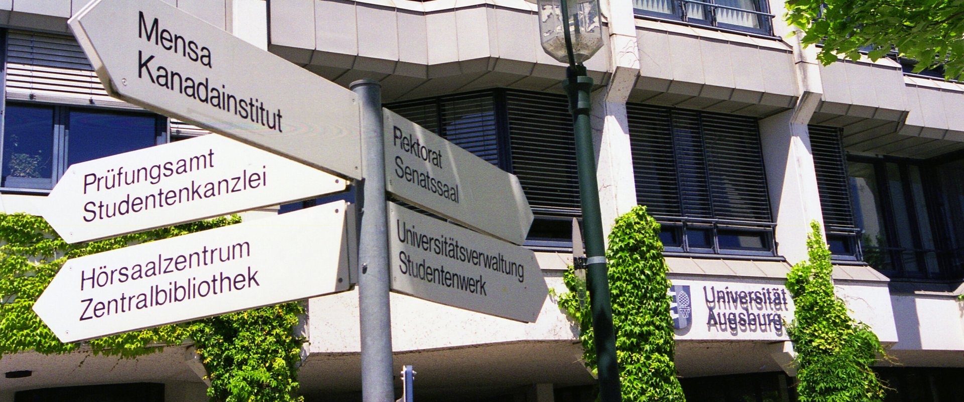 Verrwaltungsgebäude mit Wegweisern davor
