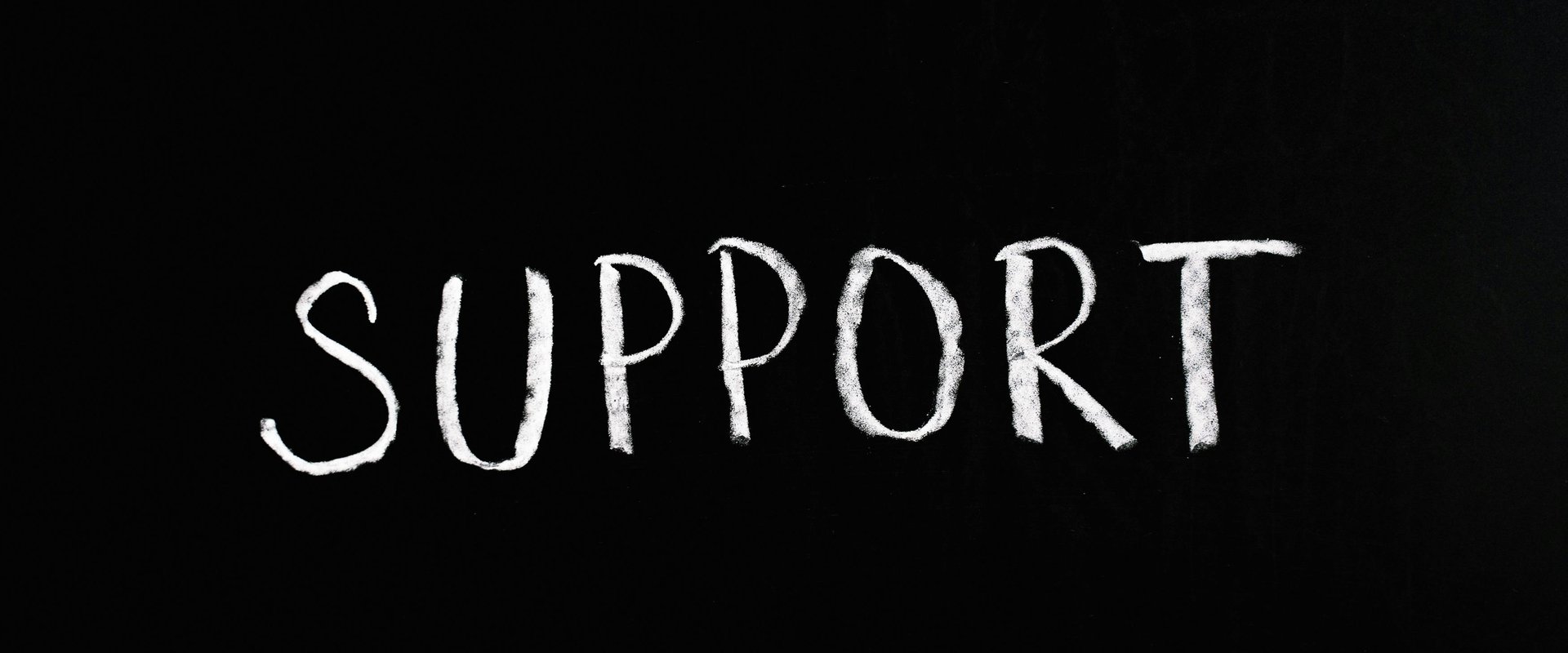 Support written in chalk on black surface