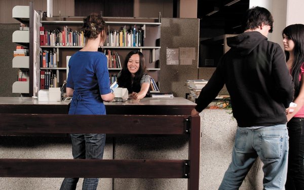 Studierende an der Ausleihtheke in der Bibliothek