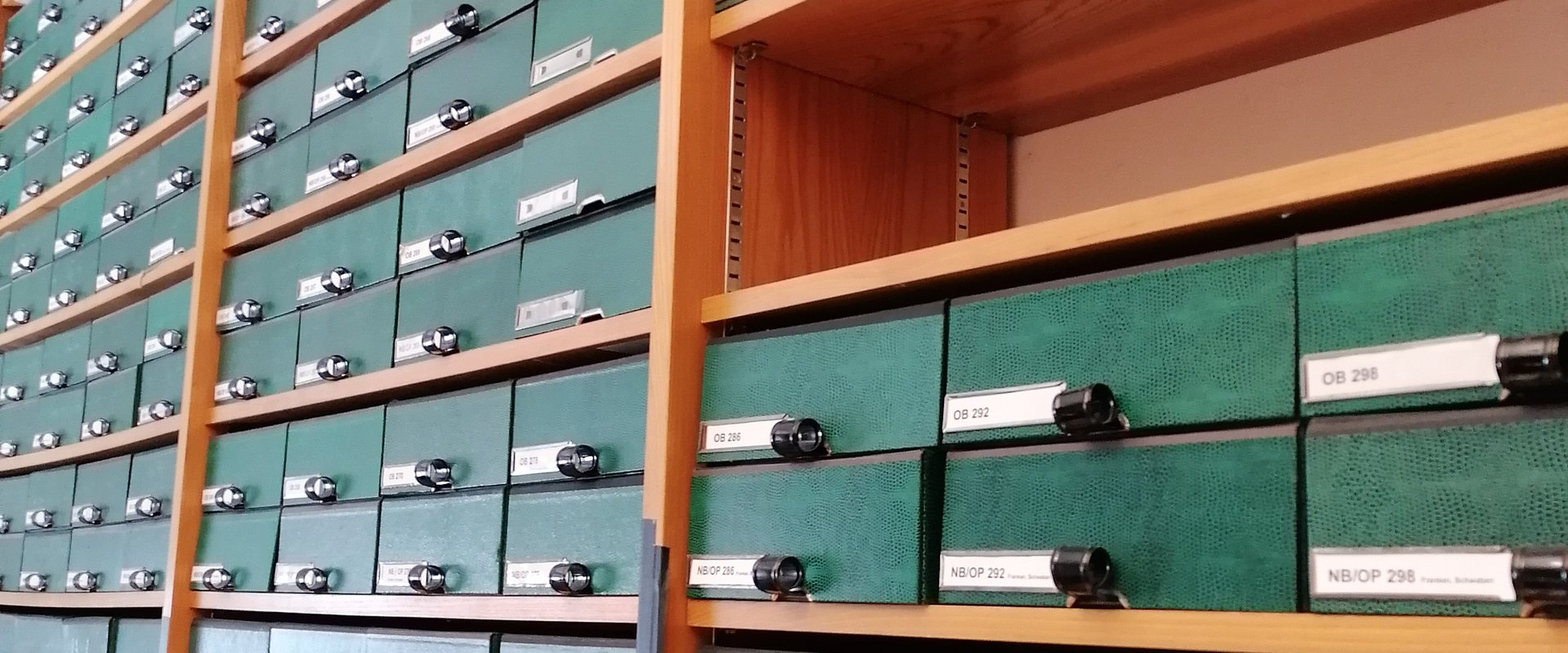 Auf dem Bild ist eine Wand des BWB-Büros zu sehen, die voller Karteikästen ist.
